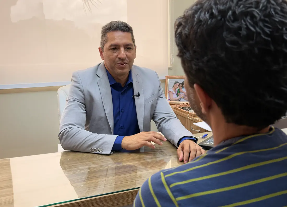 Dr. Enio Moreira Bernardo conversando com uma paciente no consultório